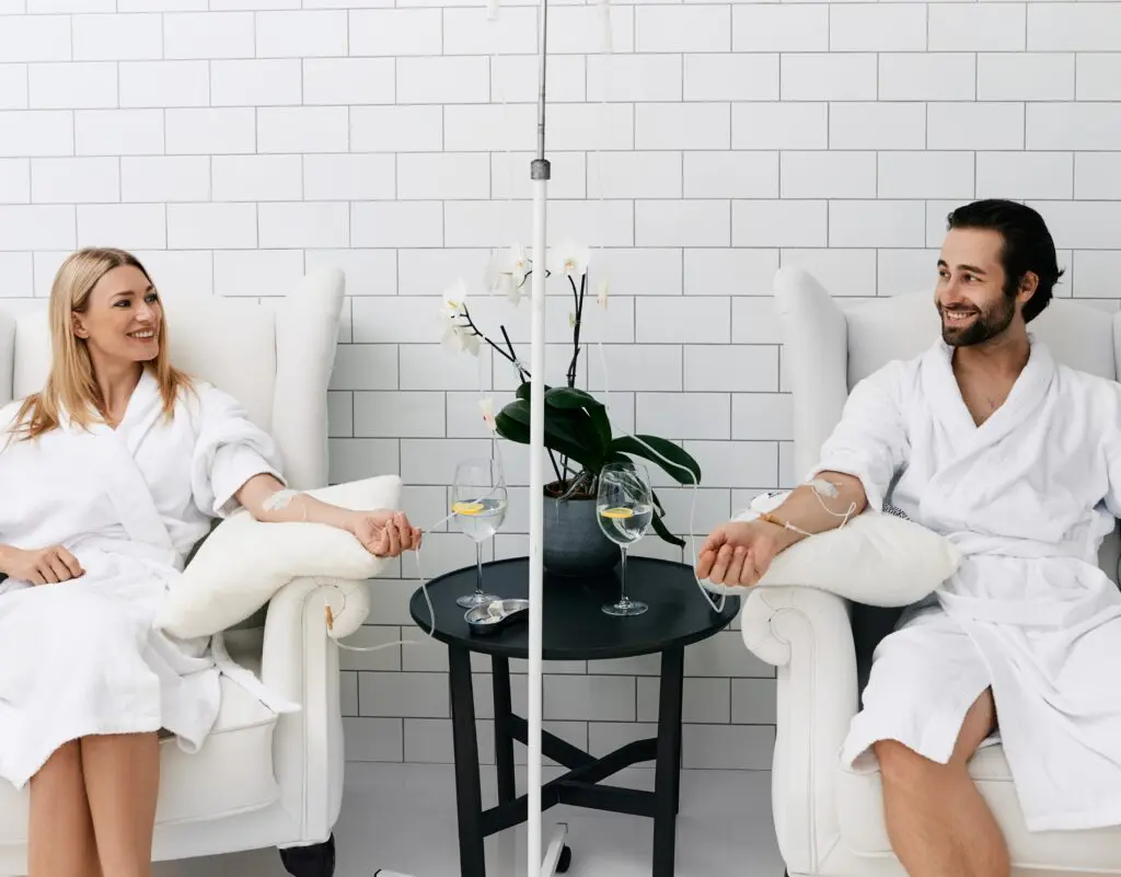 Couple receiving IV therapy in a clinic relaxed and happy